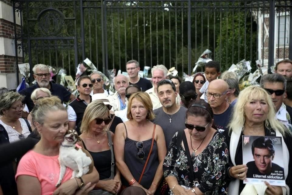 Fanáticos de Delon riendiendo tributo al actor en la puerta de su propiedad.