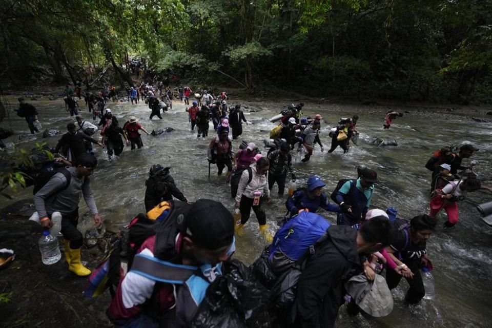 Migrantes, en su mayoría venezolanos, cruzan un río durante su viaje a través del Tapón del Darién desde Colombia a Panamá, con la esperanza de llegar a Estados Unidos, el 15 de octubre de 2022.