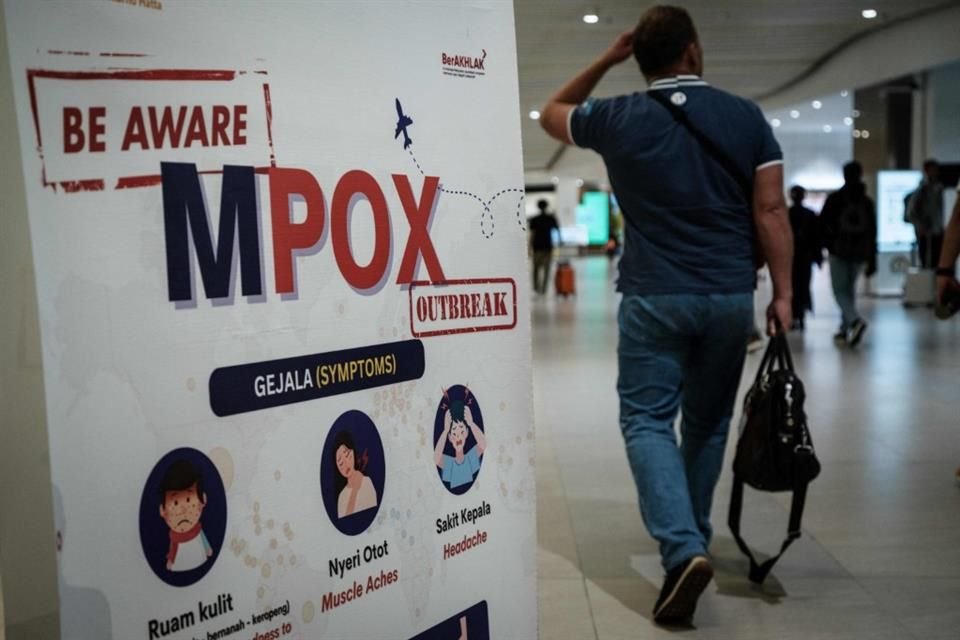 Un pasajero camina junto a un cartel informativo de mpox en el aeropuerto de Tangerang, Indonesia el 26 de agosto del 2024.