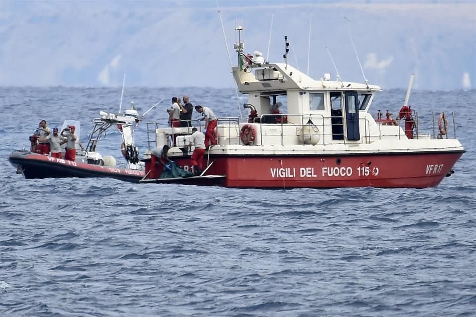 Buzos de los bomberos italianos llevan hasta un barco la bolsa con los restos mortales de una de las víctimas del naufragio del yate Bayesian, el 21 de agosto de 2024, en Porticello.