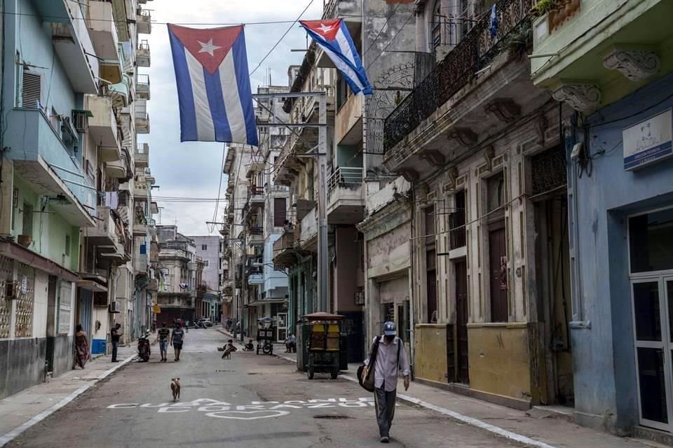 Un hombre cabina en las calles de La Habana, bajo banderas colgantes de Cuba.