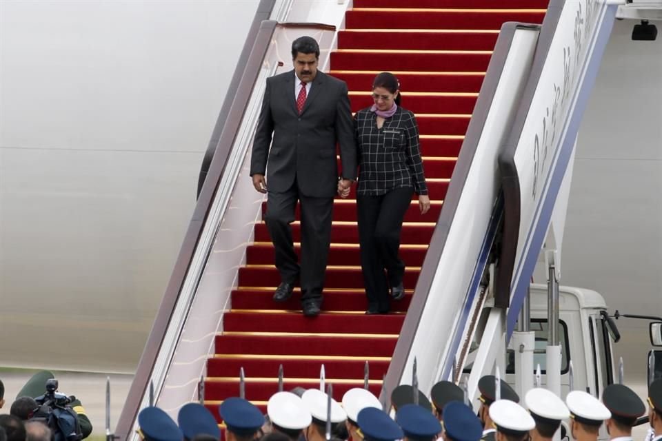 El Presidente de Venezuela, Nicolás Maduro, y su esposa, Cilia Flores, descienden de un avión al llegar al Aeropuerto Internacional de Beijing, China, en 2015.