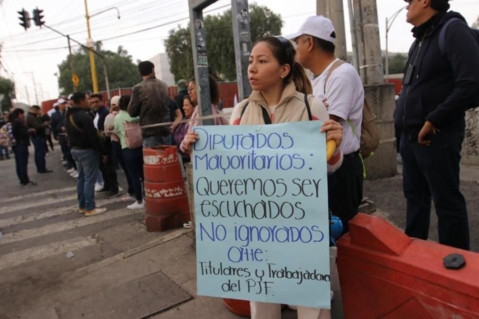 Una mujer posa en el bloqueo de San Lázaro con un cartel a favor de los trabajadores del Poder Judicial.