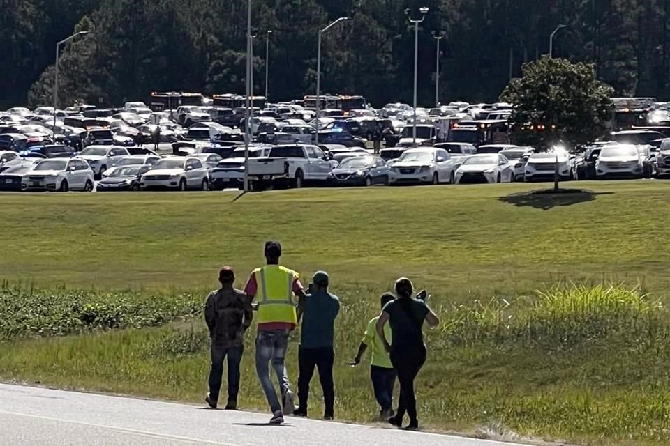 Varios alumnos son evacuados hacia el estadio de fútbol americano tras el cierre del campus de la secundaria Apalachee en Winder, Georgia.