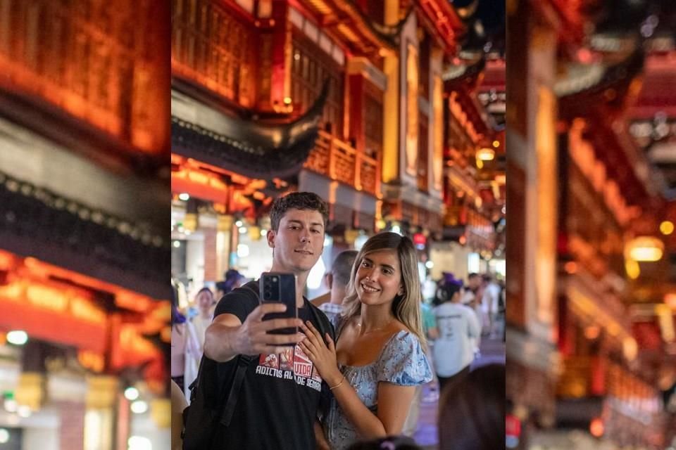 En la noche del 9 de julio de 2024, dos turistas extranjeros se hacen una foto en grupo en los Jardines Yu en Shanghai.