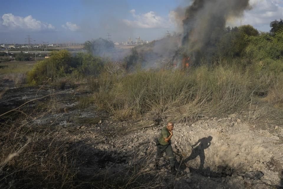 Un oficial inspecciona el área alrededor de un incendio luego de que militares dijeran que interceptaron un misil lanzado desde Yemen.