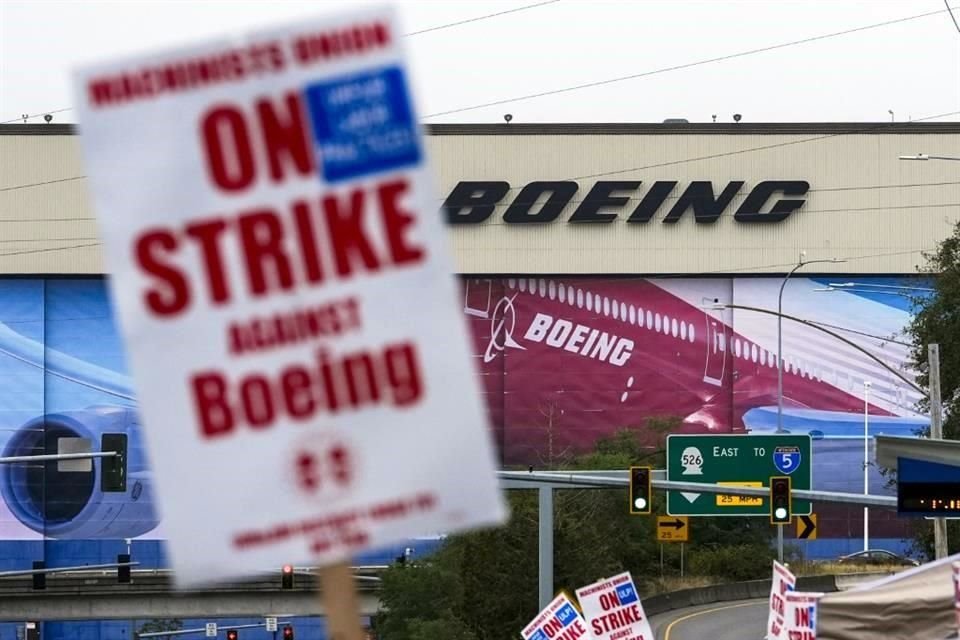 Los trabajadores de Boeing ondean carteles de huelga, después de que los miembros del sindicato votaron para rechazar una oferta de contrato, cerca de la fábrica de Everett, Washington.