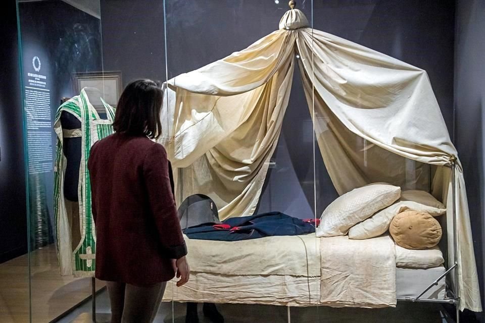 Una visitante observa la chaqueta de la guardia imperial y el sombrero usado por Napoleón en su lecho de muerte.