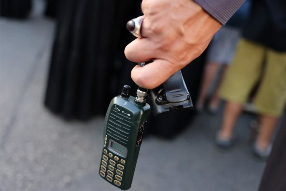 Un hombre sostiene un walkie talkie tras remover su batería durante un funeral en Líbano.