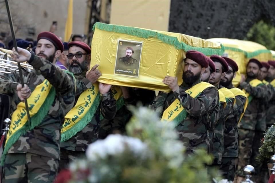 Combatientes de Hezbolá cargan los ataúdes de sus camaradas que murieron en el ataque israelí del viernes, durante su procesión fúnebre en el suburbio sur de Beirut.