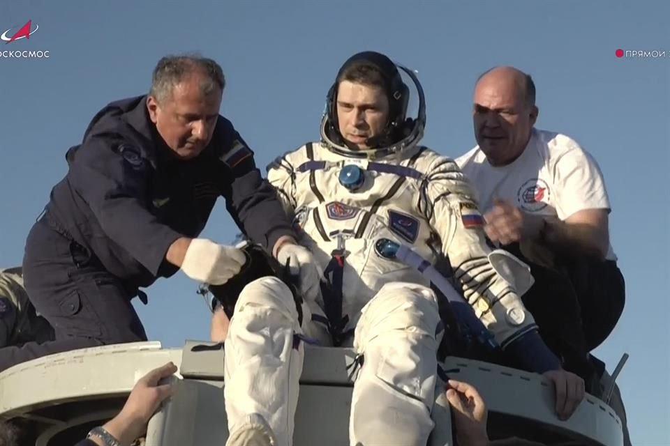 El cosmonauta Nikolai Chub es ayudado a salir de la cápsula Soyuz tras su regreso a la tierra.