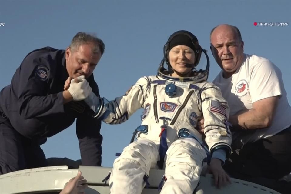 La astronauta Tracy Dyson es ayudada a salir de la cápsula Soyuz tras su regreso a la tierra.