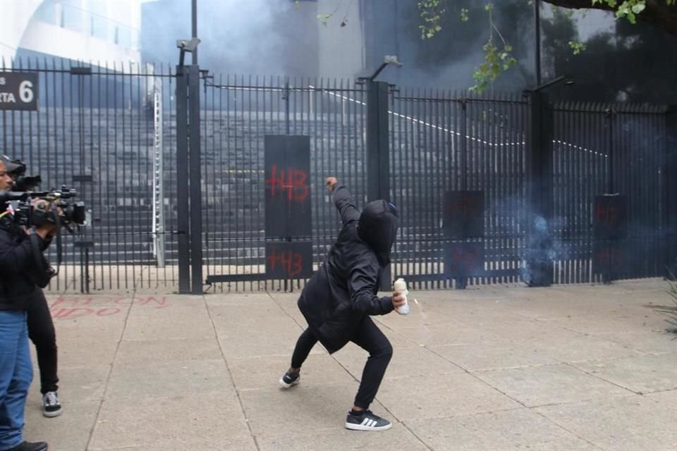 Estudiante de Ayotzinapa arroja un petardo a la sede del Senado.