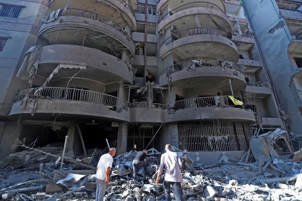 Personas revisan un edificio destruido después de los ataques aéreos israelíes, en el suburbio sur de Beirut, Líbano, el 29 de septiembre de 2024.