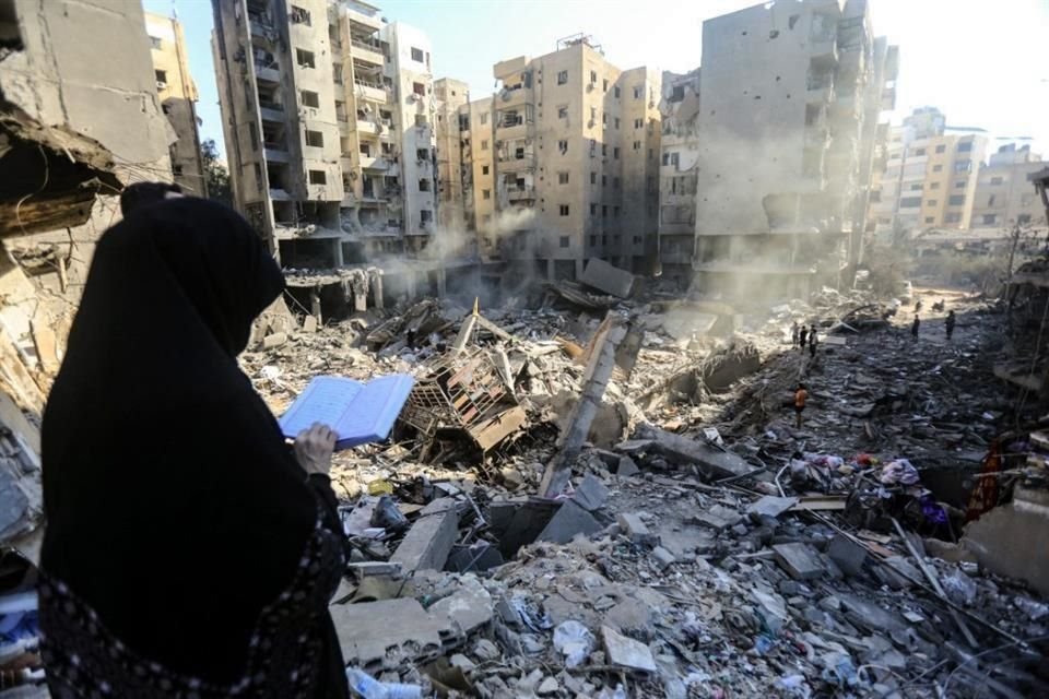 Una mujer lee el Corán frente a los escombros de los edificios que fueron arrasados &#8203;&#8203;el 27 de septiembre por ataques israelíes que atacaron y mataron al líder de Hezbolá, Hassan Nasrallah