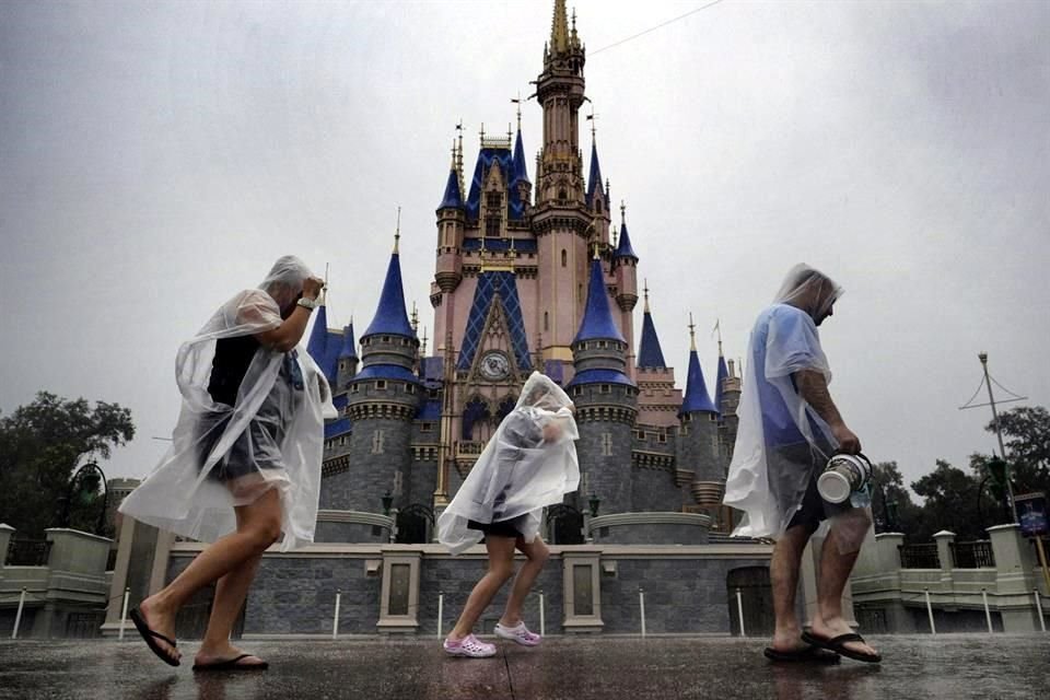 Los visitantes se enfrentan a las primeras lluvias del huracán Milton en el Magic Kingdom de Walt Disney World en Bay Lake, Florida.