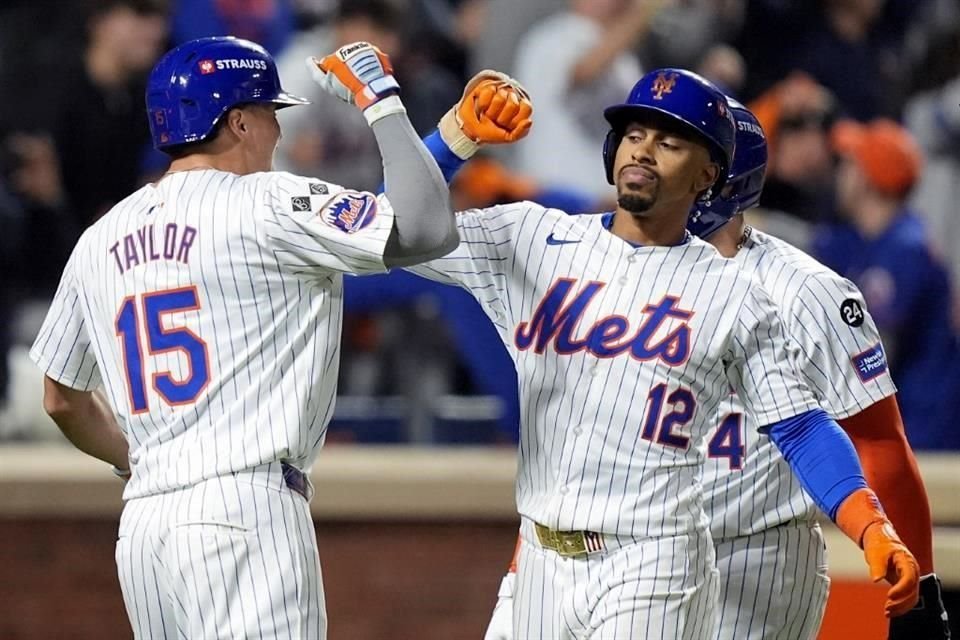 El lanzador de los Mets de Nueva York, Francisco Lindor (12), es felicitado por Tyrone Taylor después de conectar un jonrón con las bases llenas contra los Phillies de Filadelfia.