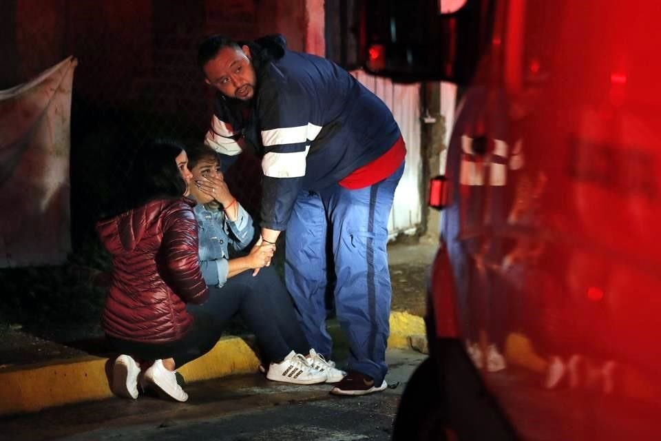 Parientes lloran a fuera de una casa en Fresnillo donde fueron masacrados dos jóvenes recientemente.