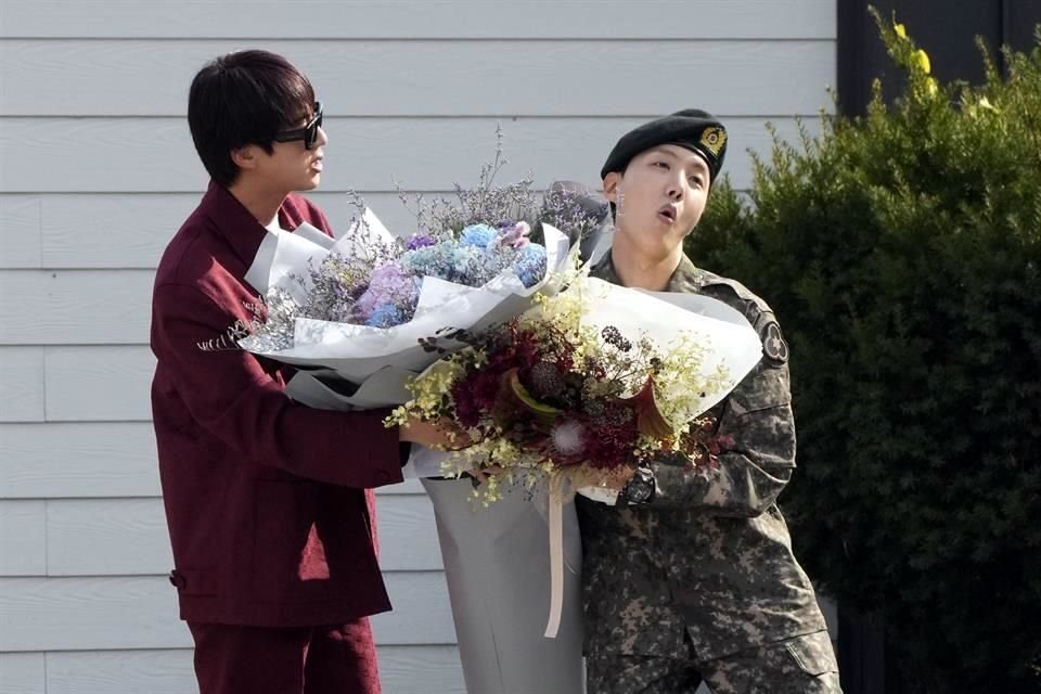 J-Hope (der.) recibió flores de su compañero de BTS, Jin (izq.), después de ser dado de baja del servicio militar obligatorio.