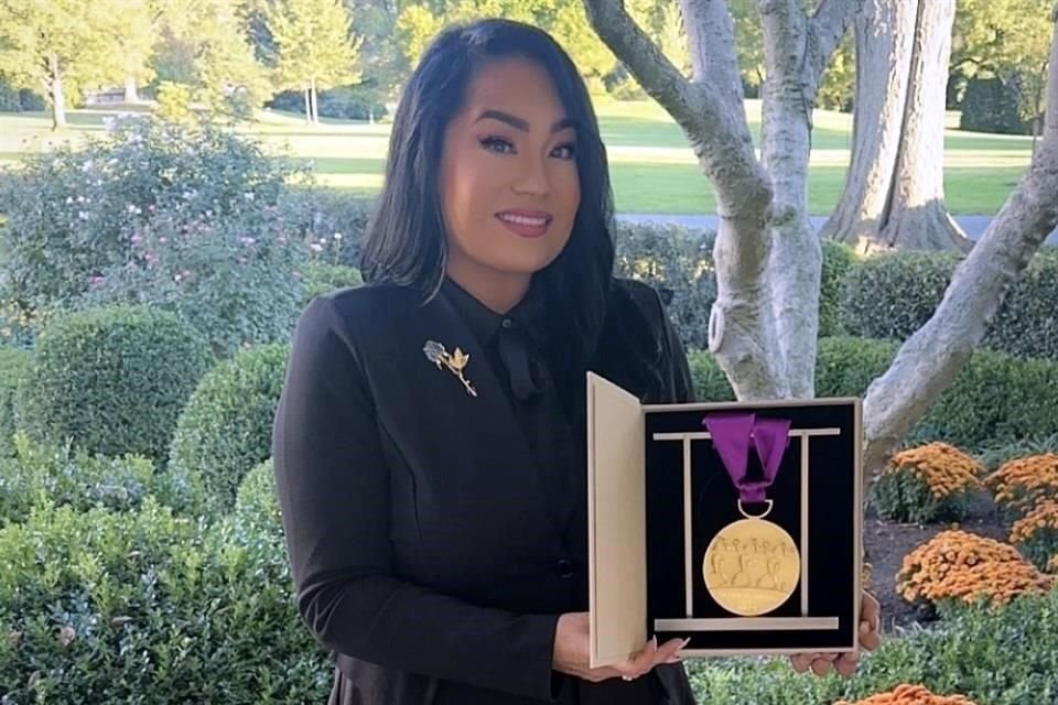 Posa hermana de Selena Quintanilla con la medalla que le dieron a su hermana en la Casa Blanca.