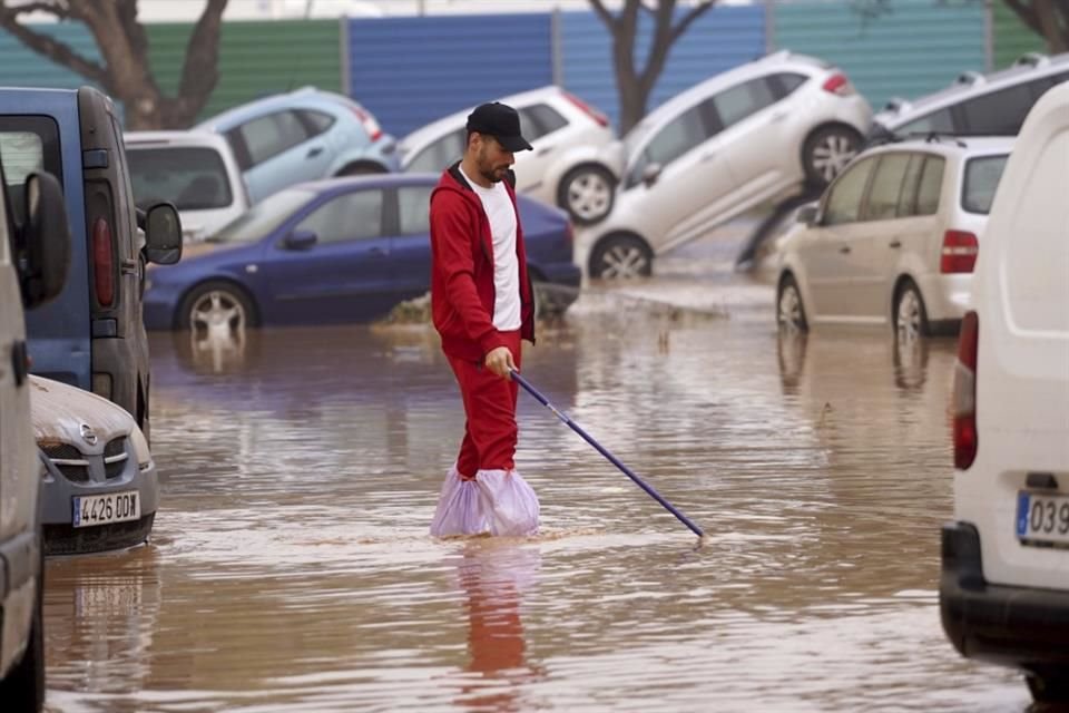 Un hombre camina entre calles inundadas en Valencia, España.