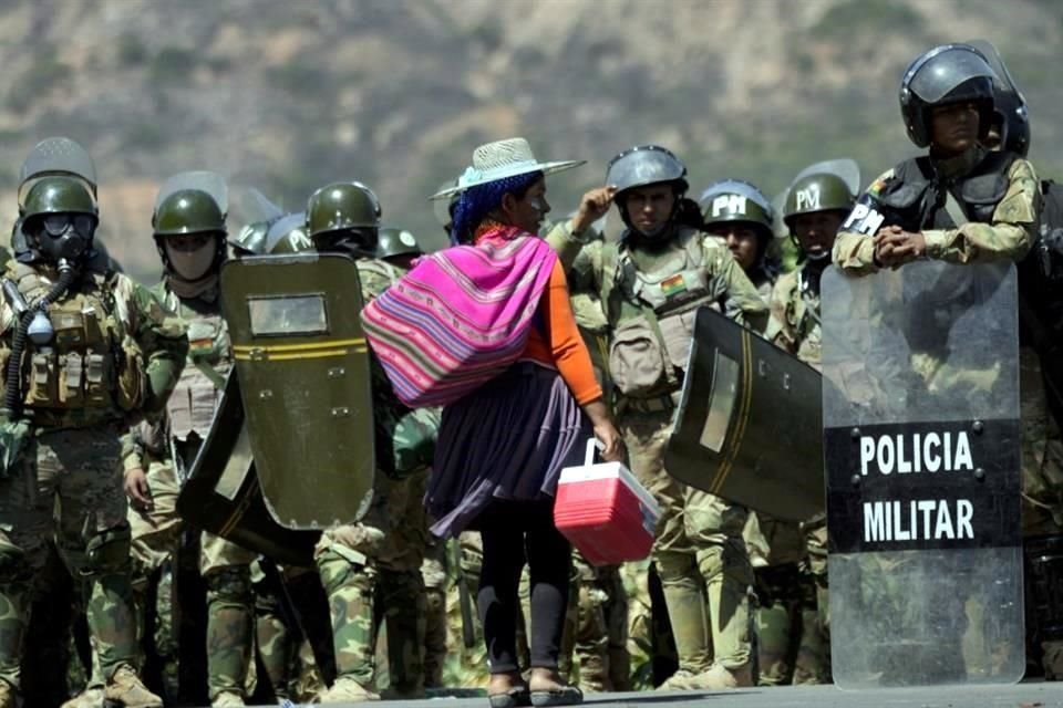 Una vendedora ofrece helados a la policía militar después de que retiraron los controles de carretera instalados por partidarios del ex presidente Evo Morales.