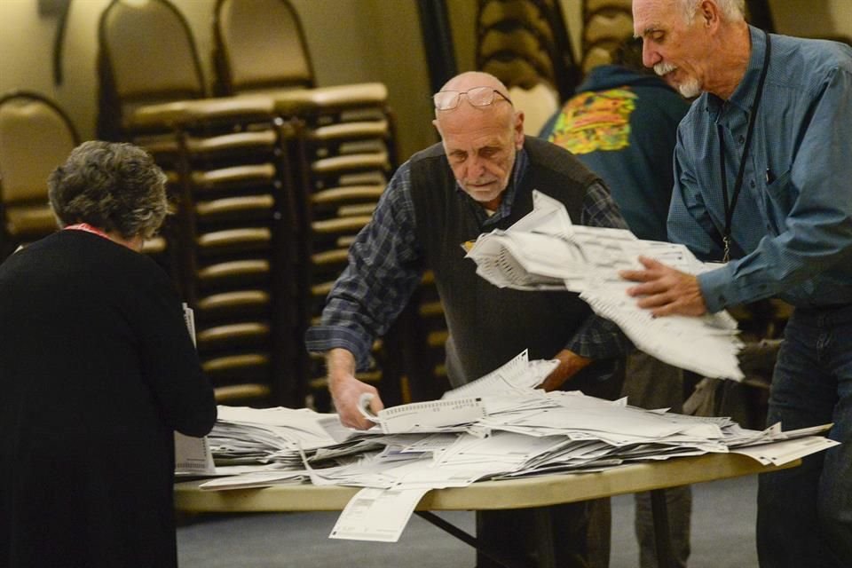 Los funcionarios electorales vuelven a contar los votos para asegurarse de que los recuentos coincidan en un centro de votación en Brattleboro, Vermont