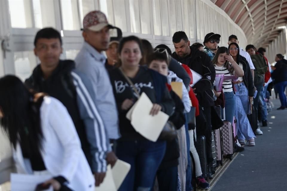 Migrantes hacen fila a la espera de que autoridades de EU examinen sus solicitudes de asilo.