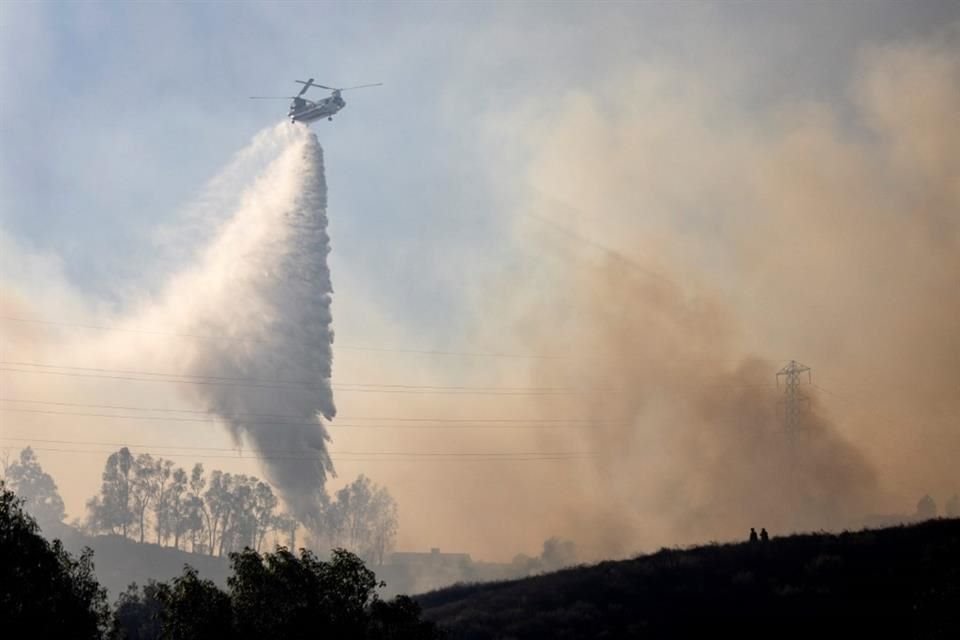 Un helicóptero rocía agua sobre un incendio en Moorpark, California, el 7 de noviembre del 2024.