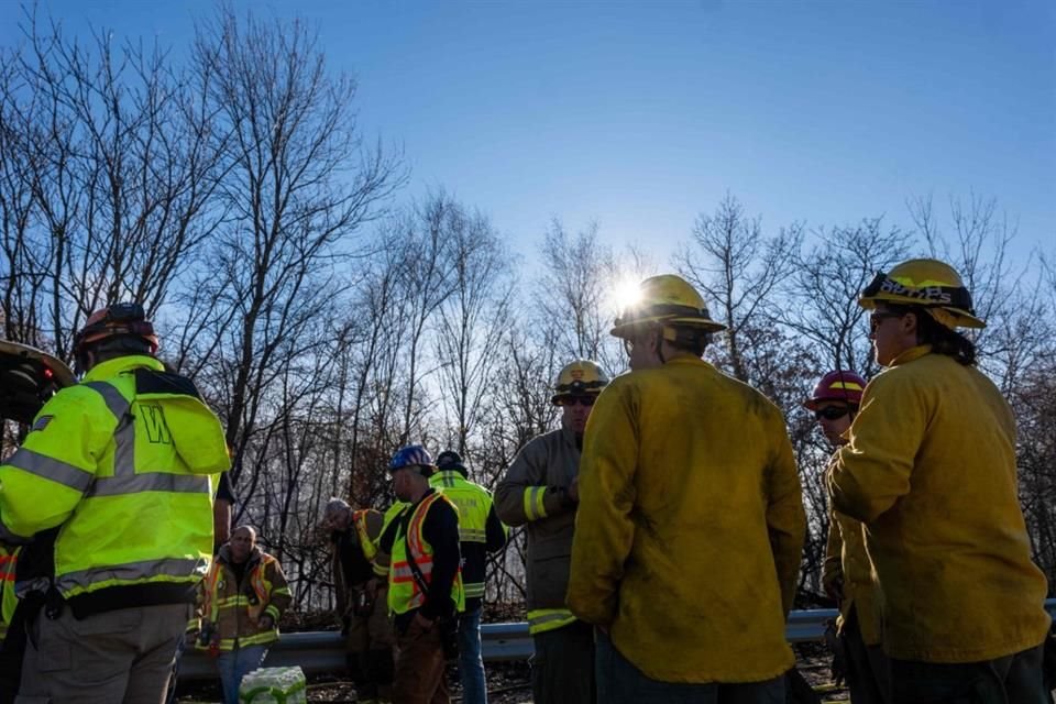 Bomberos descansan entre labores de combate de un incendio forestal en Nueva Jersey, el 9 de noviembre del 2024.