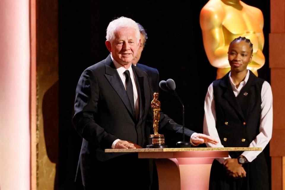 El guionista y director británico Richard Curtis (izq.) acepta el Premio Humanitario Jean Hersholt.