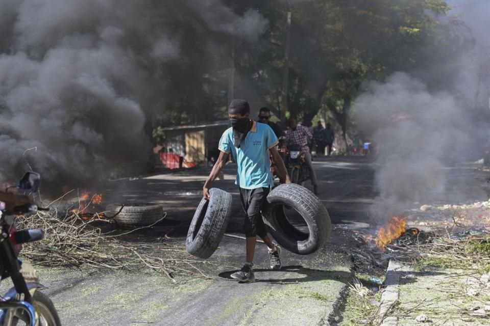 Un residente carga llantas para una barricada en Puerto Príncipe, el 19 de noviembre del 2024.