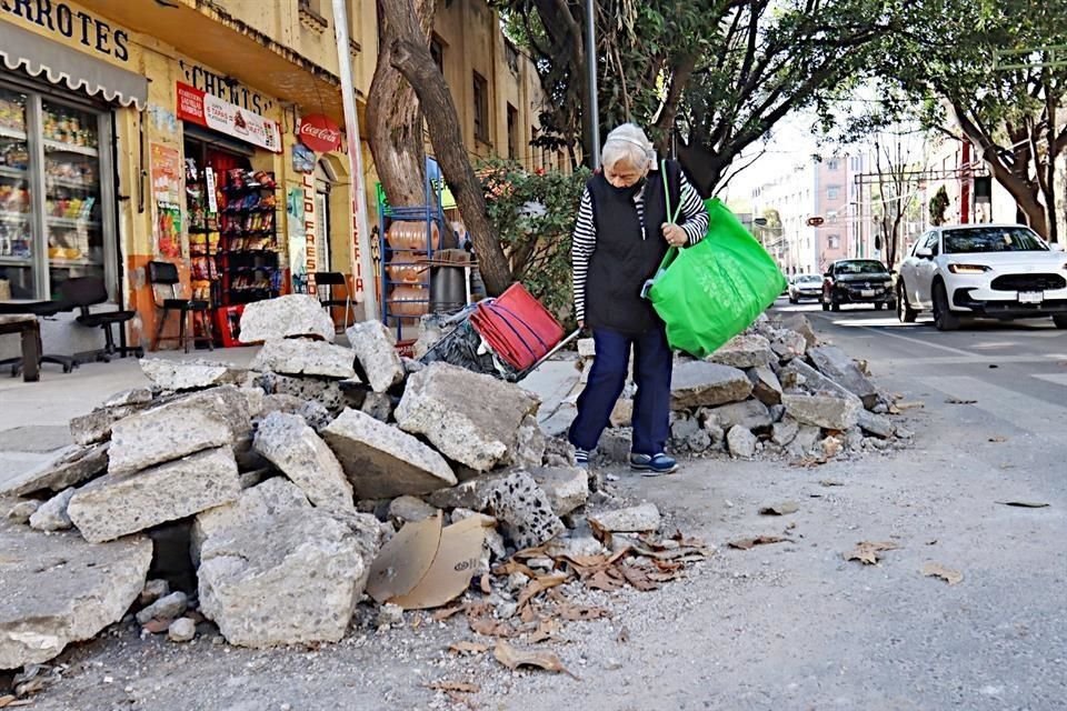 Entre concreto. Vecinos deben maniobrar para evadir el montón de escombros que bloquea aceras y calles.