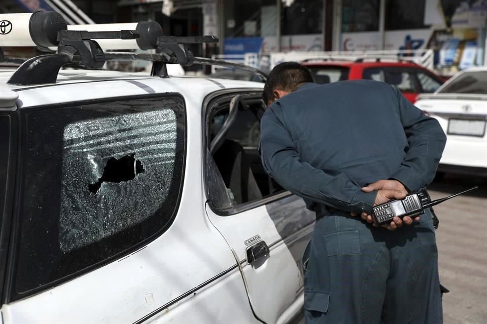 Un policía ve la camioneta donde mataron al portavoz de Afganistán.