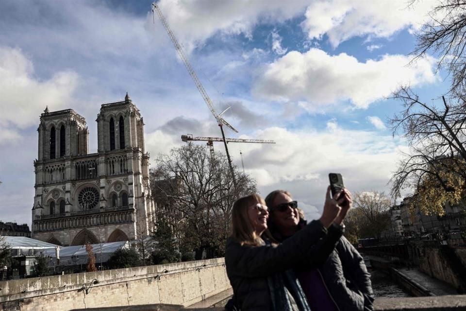 Personas se toman una selfie frente a la catedral de Notre Dame.