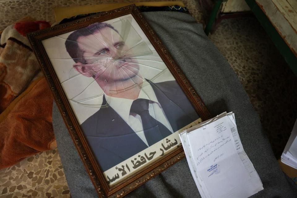 Un retrato del Presidente sirio, Bashar al-Assad, está roto en el piso en una oficina gubernamental de la ciudad de Hama que fue tomada por los rebeldes.