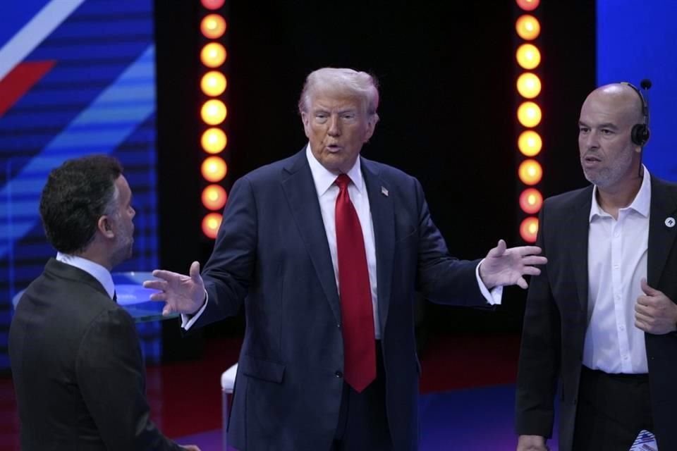 El presidente electo Donald Trump habla con Enrique Acevedo (izq,), conductor de Televisa, durante un receso de la entrevista en los estudios de Univision, en Florida.