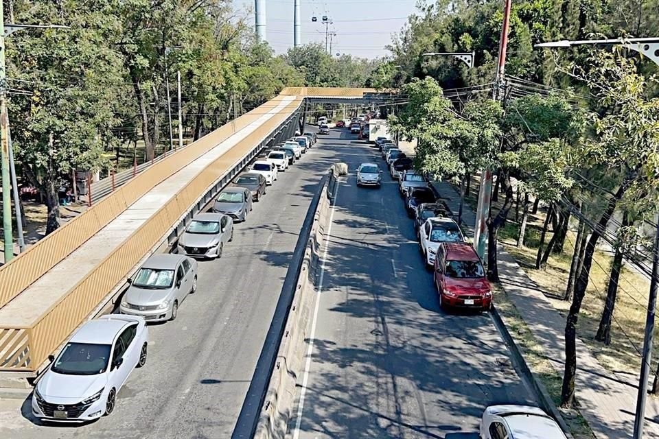 Vehículos son estacionados a los costados del puente en construcción.