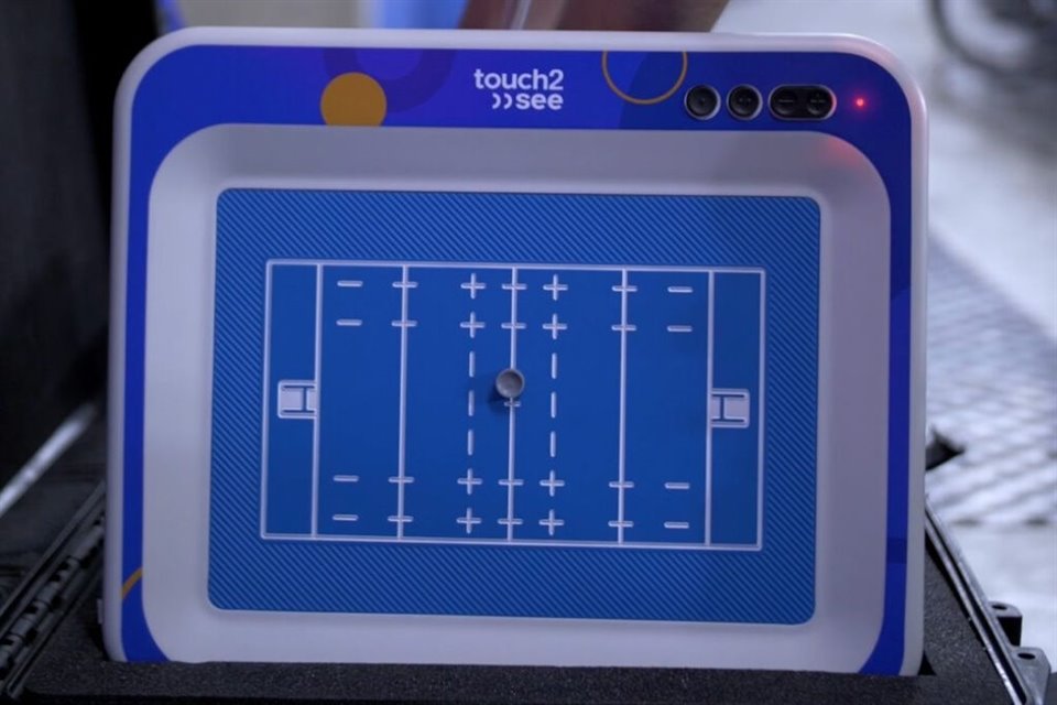 Es una tableta con un cursor magnético que replica los movimientos de la pelota en el campo de manera inmediata. Además, cuenta con vibración y audiodescripción.