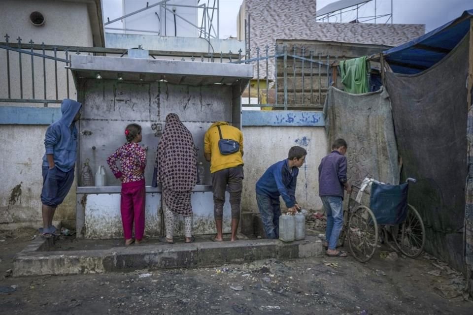 Infantes palestinos recolectan agua en un campo de desplazados en la Franja de Gaza, el 12 de diciembre del 2024.