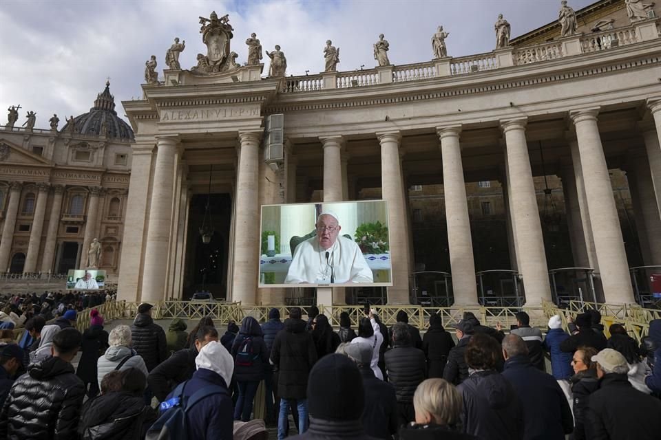 Fieles observan en una pantalla gigante el mensaje del papa Francisco, en la Plaza San Pedro, en el Vaticano, el domingo 22 de diciembre de 2024.