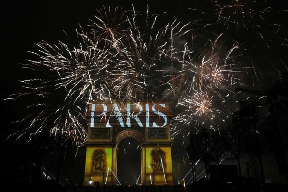 Fuegos artificiales iluminan el cielo alrededor del Arco del Triunfo en la Avenida de los Campos Elíseos de París a principios del 1 de enero de 2025, durante las celebraciones de Año Nuevo.