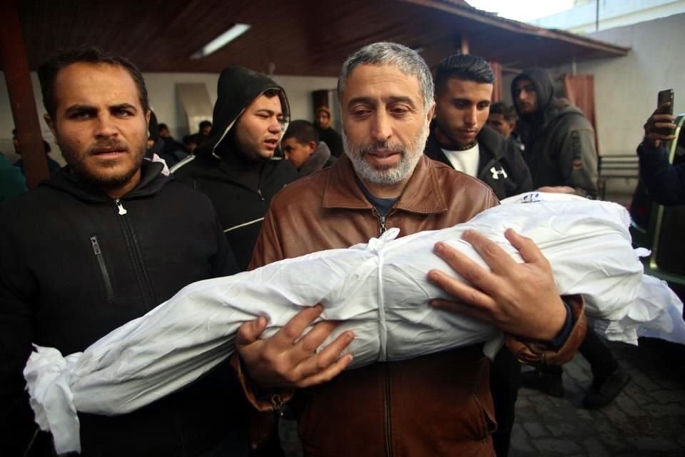 Un hombre palestino lleva el cuerpo de un familiar, muerto en un ataque israelí la noche anterior, antes del funeral frente al hospital árabe Al-Ahli, en Gaza.