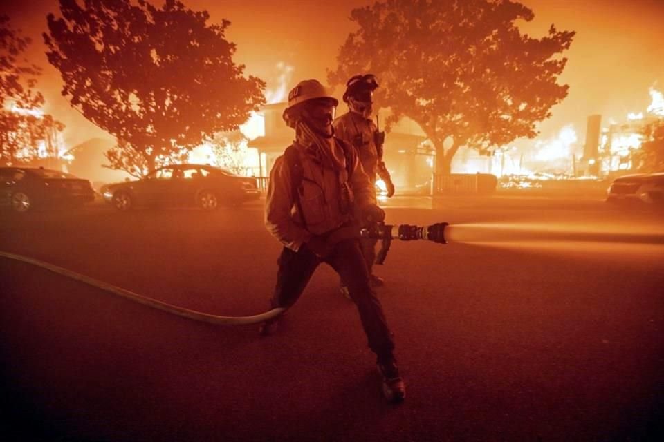 Los bomberos luchan contra el incendio Palisades mientras quema múltiples estructuras en el vecindario Pacific Palisades de Los Ángeles.