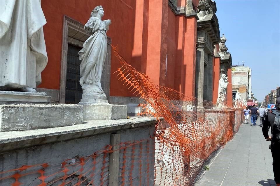 Unidas entre sí por una red de hule naranja que trata de protegerlas, las estatuas muestran signos de vandalización.