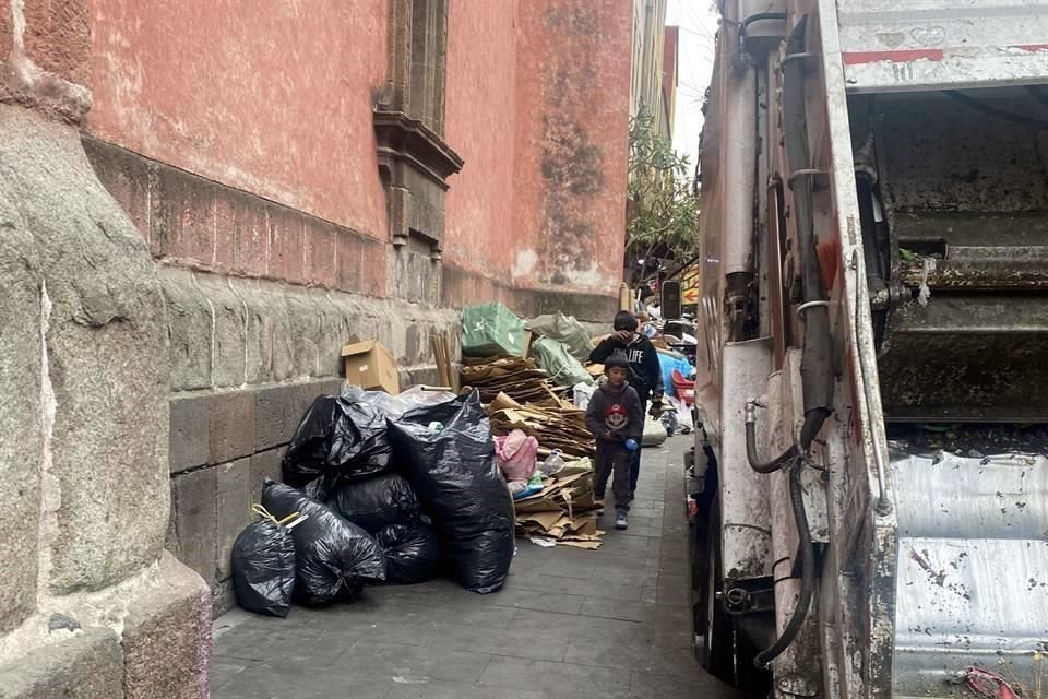 Cartones y bolsas de basura se acumulan a un costado del recinto religioso; donde también se paran camiones del servicio de basura.