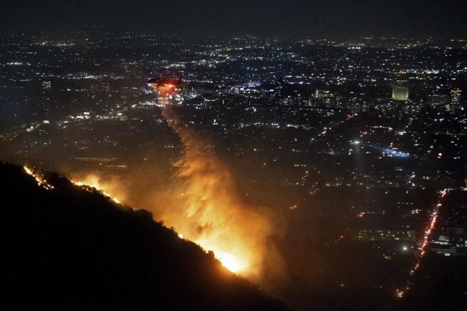 Un helicóptero lanza agua en un incendio en Hollywood Hills, en Los Ángeles, el 8 de enero del 2025.