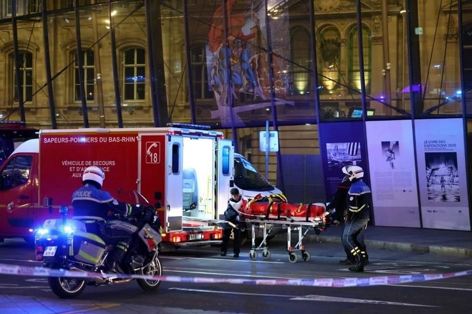 Seorang petugas pemadam kebakaran dibantu oleh petugas polisi untuk mengangkut orang yang terluka dengan tandu di luar stasiun kereta Strasbourg menyusul tabrakan antara dua trem.