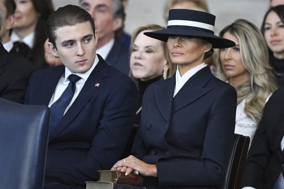 Barron Trump y la primera dama Melania Trump escuchan mientras el presidente Donald Trump pronuncia sus comentarios.