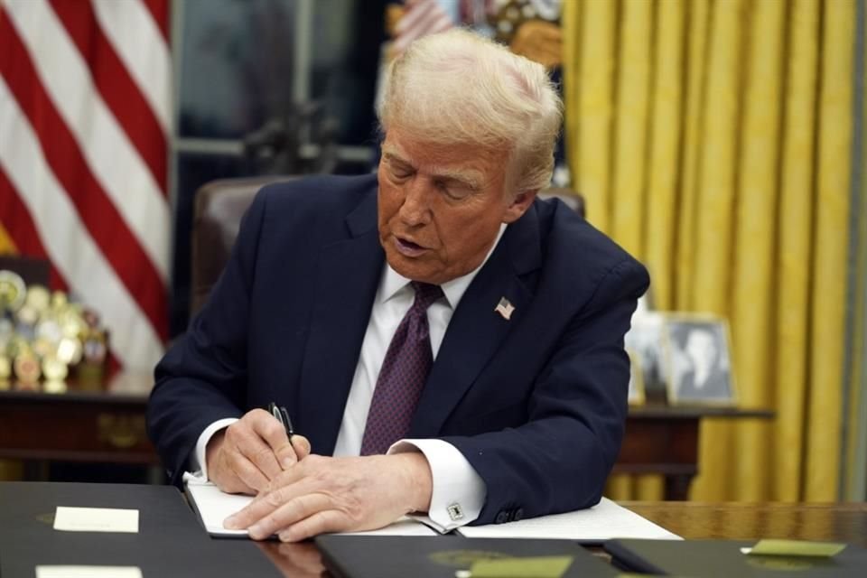 El Presidente Donald Trump firma órdenes ejecutivas en la Oficina Oval.